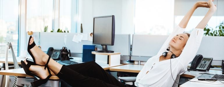 Mujer relajada en una oficina tras aplicar las técnicas de respiración para evitar el estrés