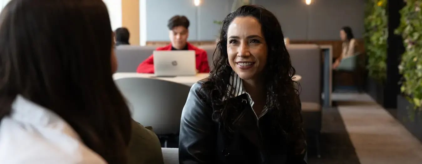 Colaboradora conociendo a su cliente en una oficina de IZA