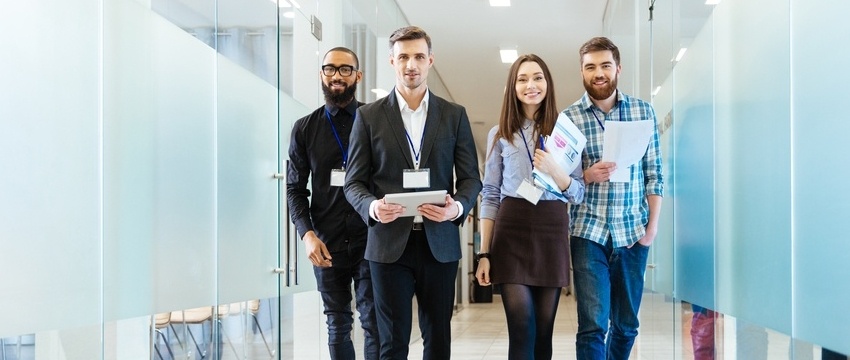 Full length of group of happy young business people walking the corridor in office together-414275-edited.jpeg