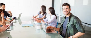 hombre joven en una reunión laboral viendo a la cámara