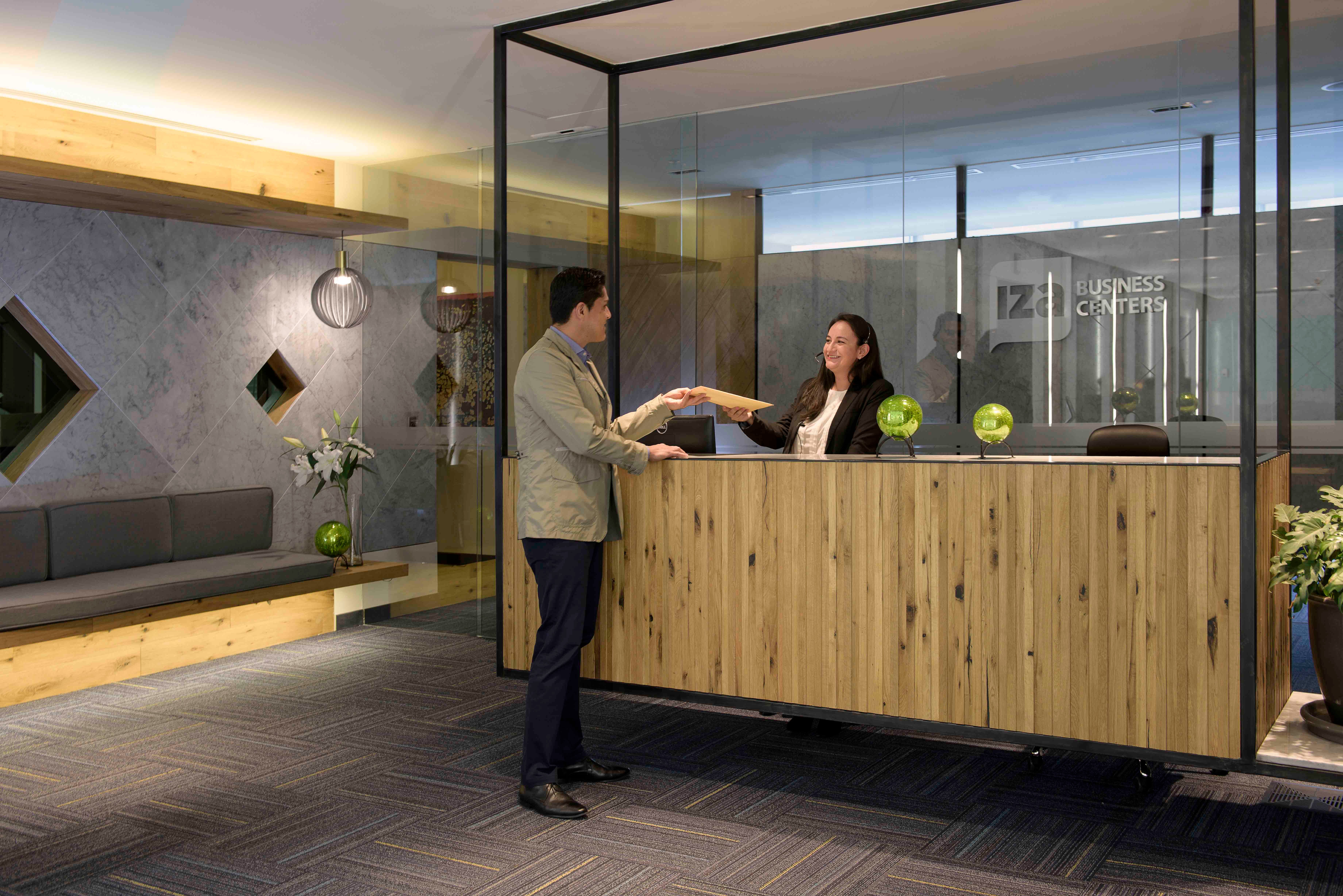 Recepcion IZA Business Centers atendiendo cliente oficina