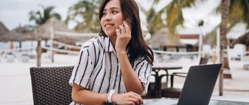 Mujer joven atendiendo sus negocios en la playa