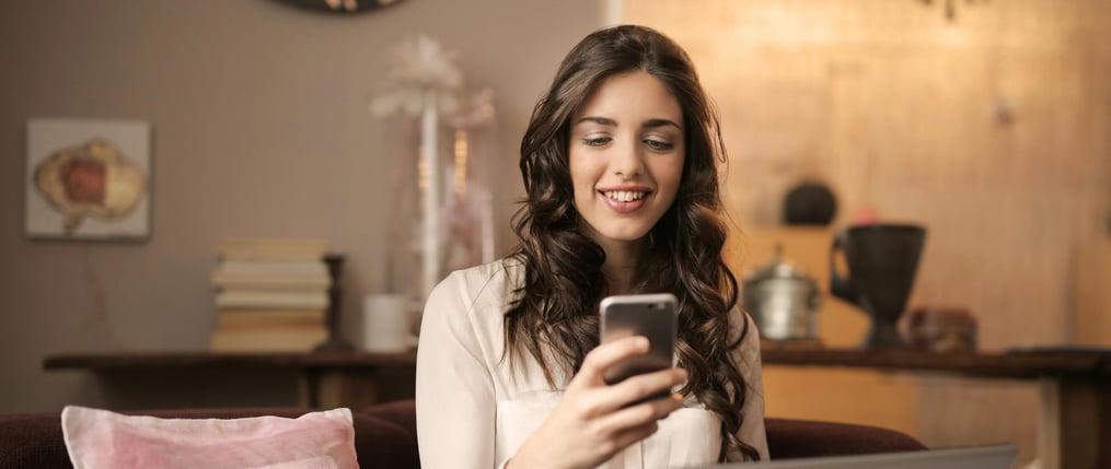 Mujer revisando el celular aprovechando los beneficios de tener un emprendimiento digital