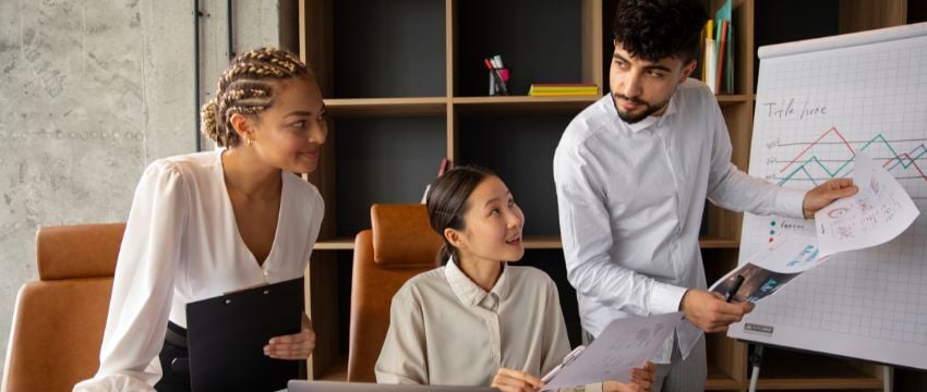 Tres emprendedores reunidos discutiendo cómo hacer crecer un negocio, compartiendo e intercambiando tips y buenas prácticas para conseguir crecer su empresa