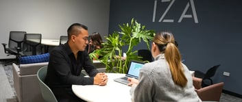 Colaboradora de IZA mostrando programa de IA a cliente en IZA Park Plaza Workhub