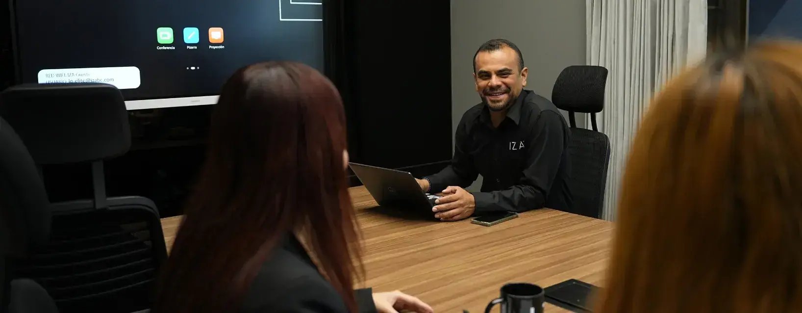 Colaborador sonriente en sala de juntas de IZA Latitud Polanco CDMX