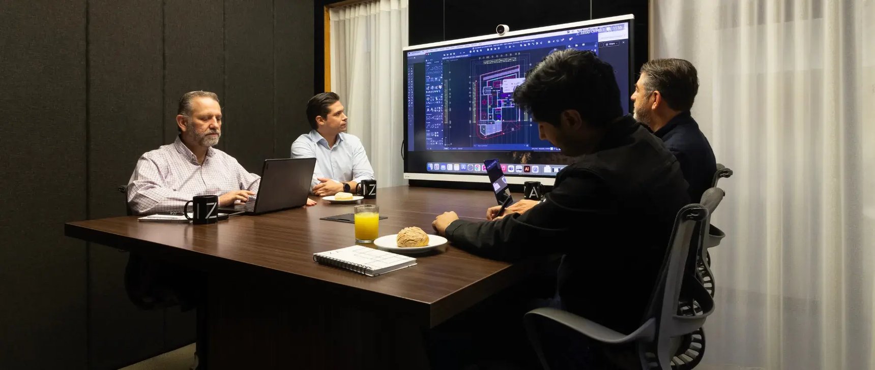 Personas en una de sus juntas de trabajo dentro de una sala de juntas en centro de IZA Nuevo Sur Monterrey