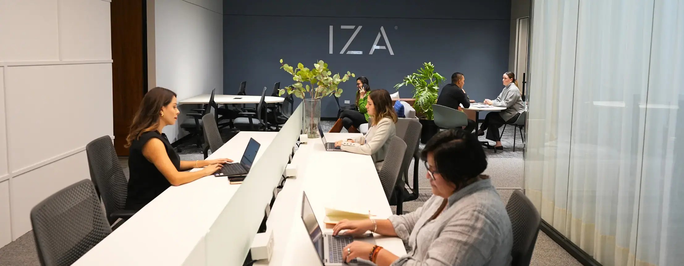 Colaboradores trabajando en sus laptops en cowork de IZA Park Plaza