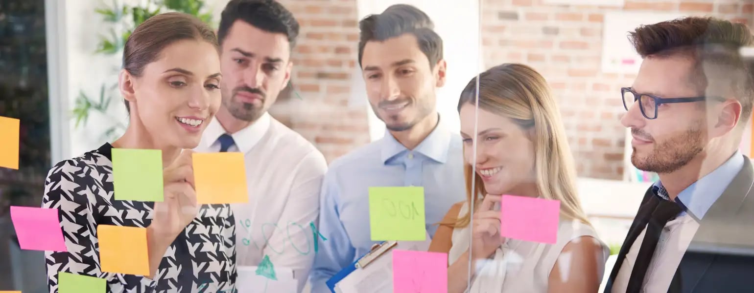 Colaboradores proponiendo ideas en post its para mejorar la cultura organizacional