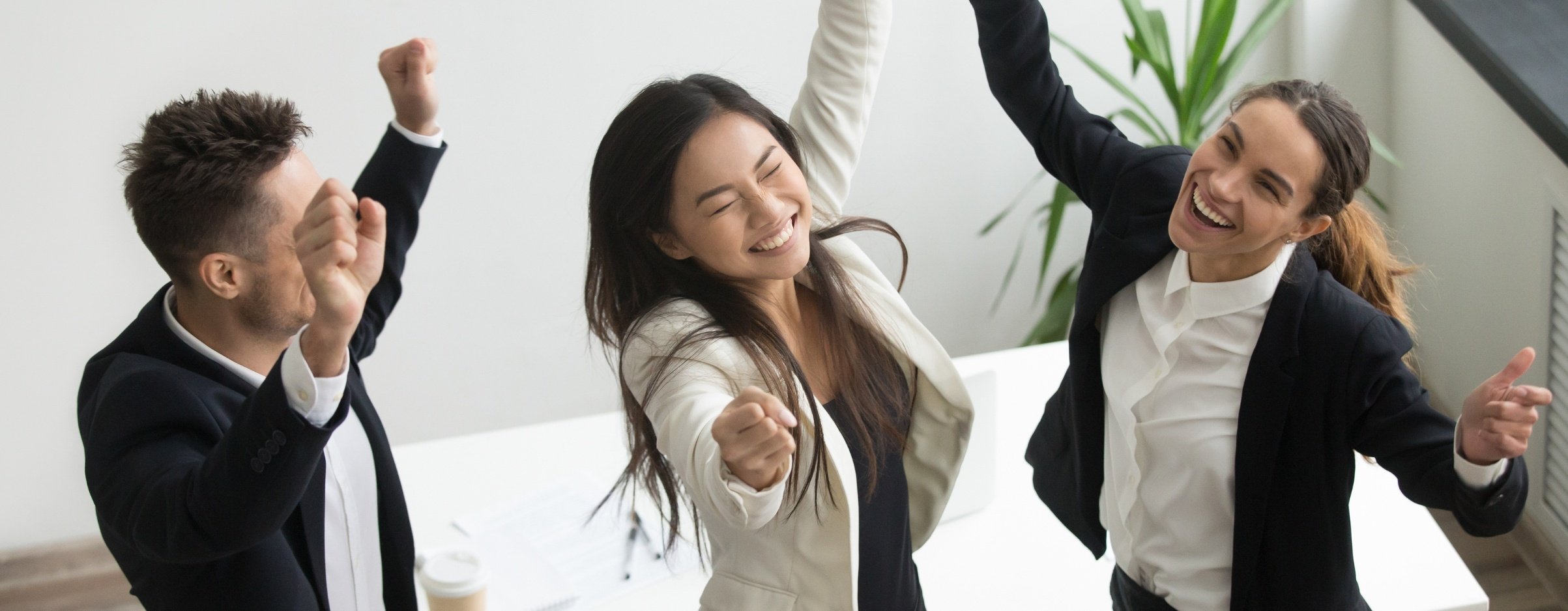 Trabajadores de oficina celebrando que han superado la desmotivación laboral