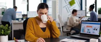 Mujer aprovechando las ventajas de tener café en su oficina en IZA Center