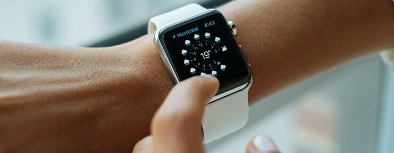 Persona revisando la hora y usando una app en su apple watch