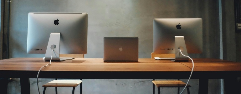 Macbooks en un escritorio de una oficina equipada