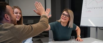 Colaboradores chocando las manos luego de hacer un trabajo en equipo exitoso