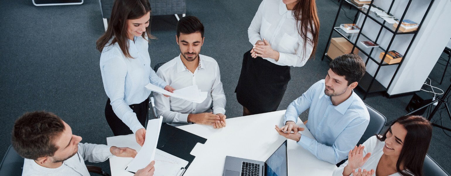 Colaboradores en oficina reunidos por un trabajo en equipo