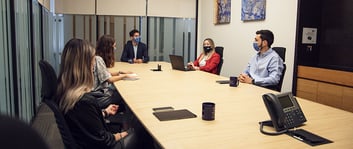personas en una reunión laboral usando cubrebocas