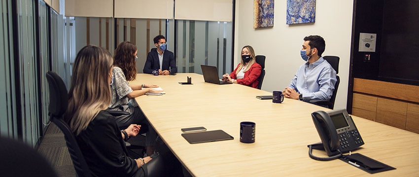 personas en una reunión laboral usando cubrebocas