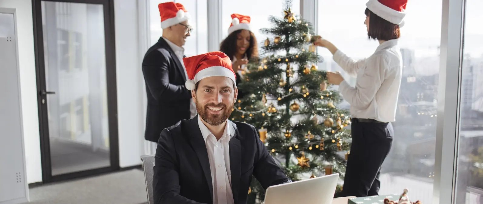Equipo de trabajo poniendo la decoración navideña en su oficina