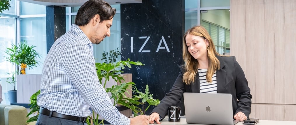 Trabajadores revisando plan de membresías para rentar oficinas en edificio de IZA