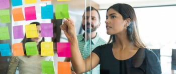 Mujer definiendo con notas adhesivas el tono de voz para una estrategia de marketing de una marca