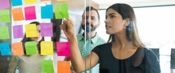Mujer definiendo con notas adhesivas el tono de voz para una estrategia de marketing de una marca