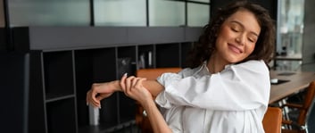 Mujer tomando un microdescanso para estirarse y aumentar la productividad en el trabajo