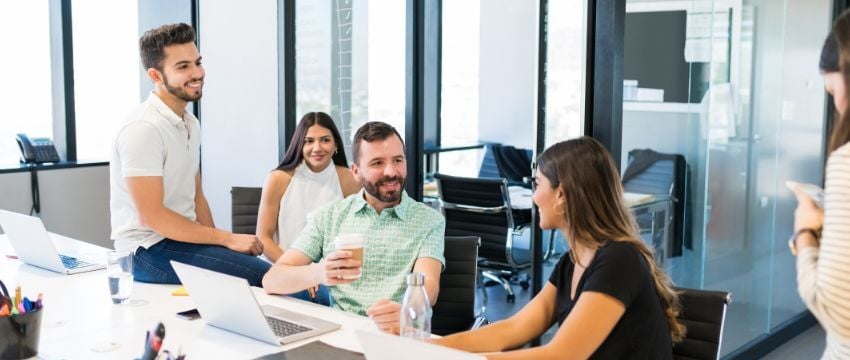 Espacio laboral de coworking con sillas y escritorios compartidos, mostrando algunas ventajas de por qué rentar una oficina