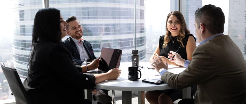 Colaboradores en Torre Diana de oficinas IZA trabajando en una mesa redonda