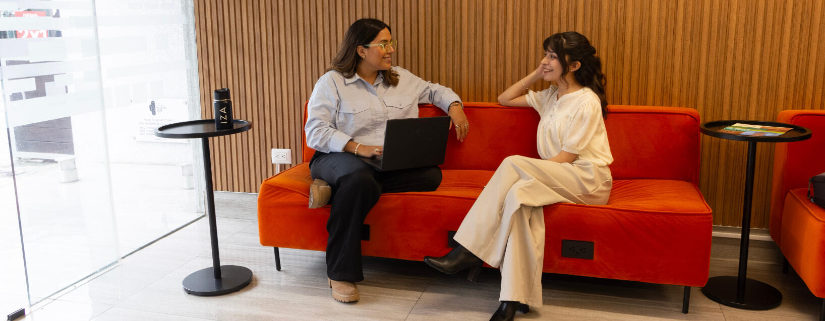 Mujeres felices usando un área de descanso de los espacios de trabajo de IZA en Nuevo Sur de Monterrey