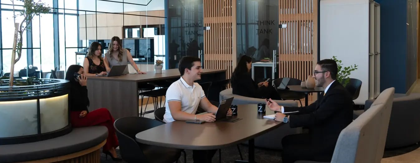 Colaboradores en espacios de coworking cómodos en oficinas de IZA en Urban Center de Guadalajara