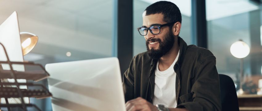 Hombre frente a la computadora consultando las tendencias empresariales para el 2024