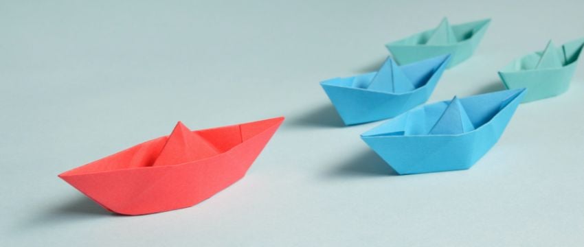 Barcos de papel que muestran los tipos de liderazgo empresarial.